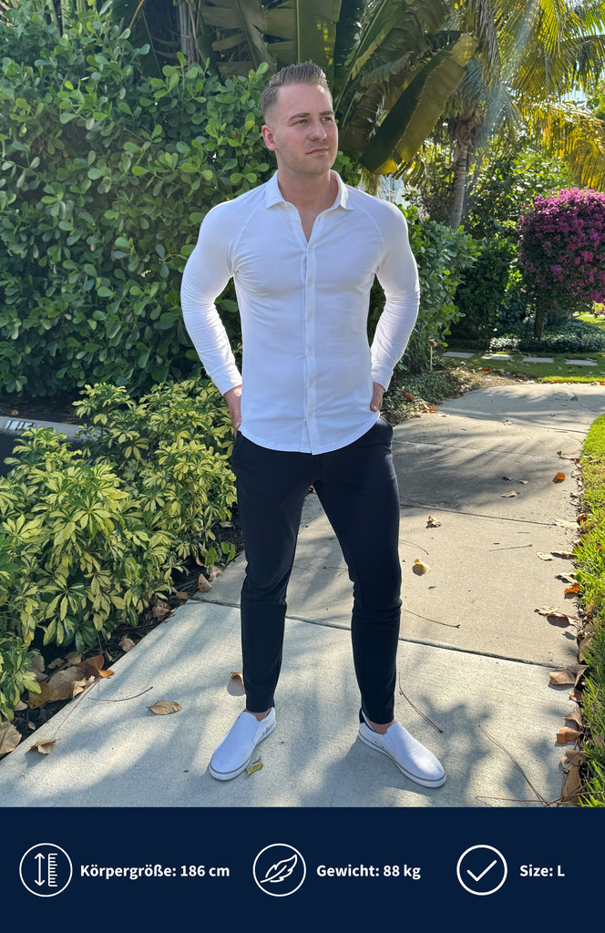 Model trägt weißes Slim Fit Jerseyhemd mit Pflanzen im Hintergrund.