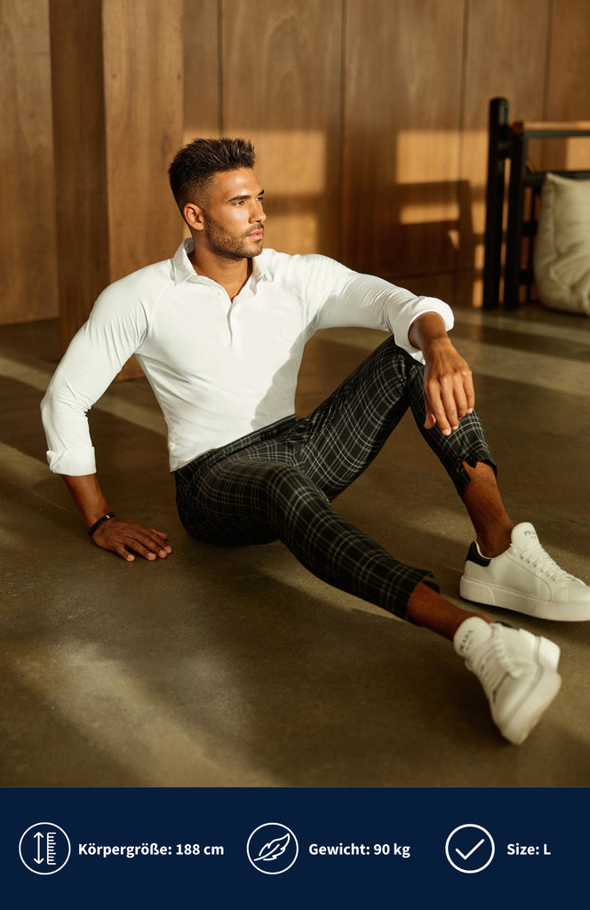 Model trägt ein weißes Athletic Slim Fit Polohemd in weiß und sitzt auf den Boden.
