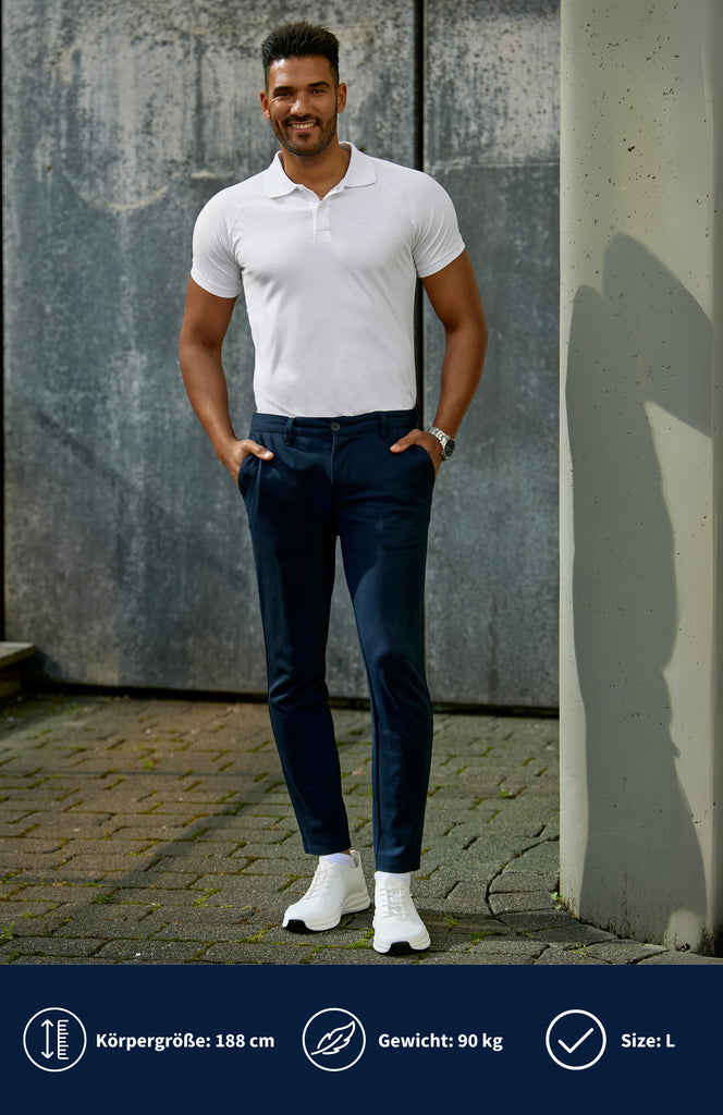 Model trägt ein weißes Slim Fit Poloshirt mit dunkelblauer Hose und steht vor einer grauen Wand.