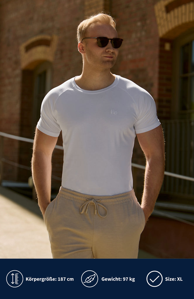 Model trägt ein weißes Slim Fit Stretch T-Shirt mit EC Logo.
