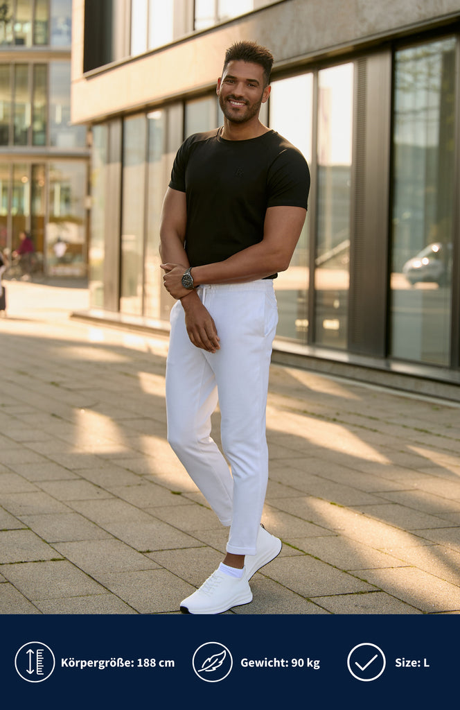 Model trägt ein schwarzes Slim Fit T-Shirt mit weißes Hose.